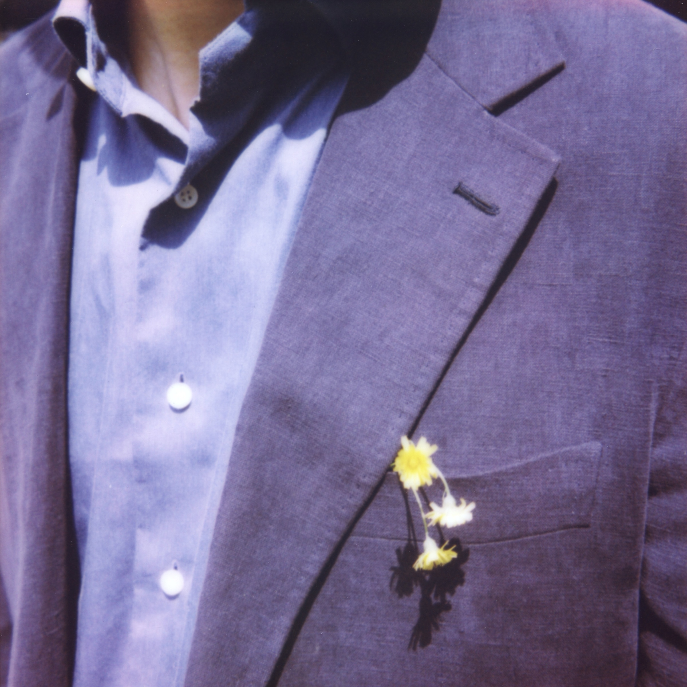 A cropped figure in a suit with small flowers